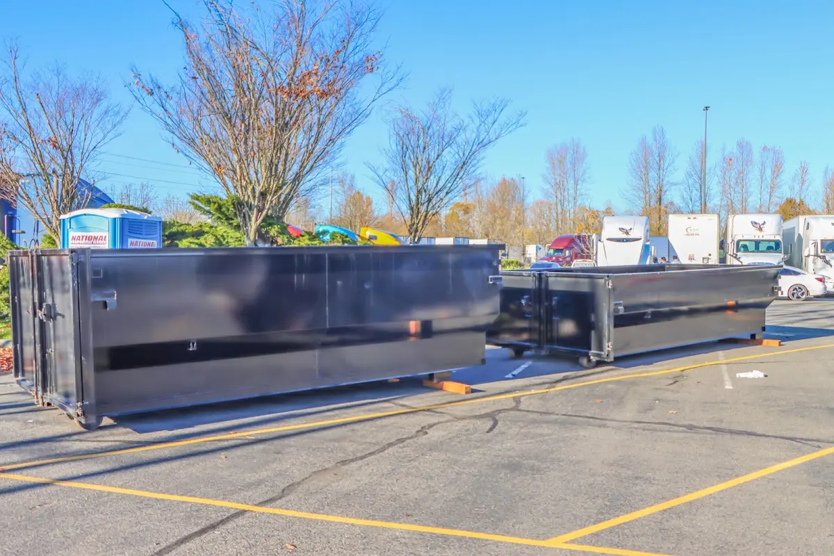 Professional dumpster rental service with roll-off container on residential driveway in East Vincent